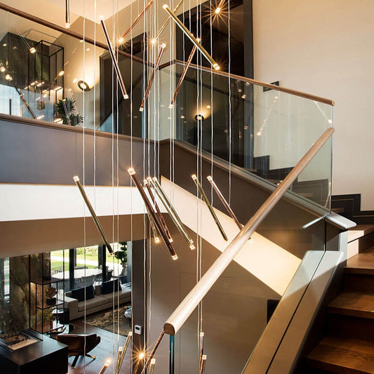 Lodes A-Tube Nano Duo chandelier in a staircase with wooden steps and a glass baulstrade
