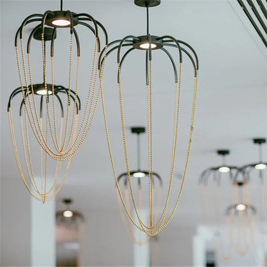 Axo Light Alysoid Pendant with brass beads hanging in a group on a white ceiling