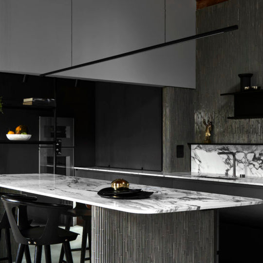 Highline Linear Pendant in Black over Marble Kitchen Island with Dark Grey Woodwork