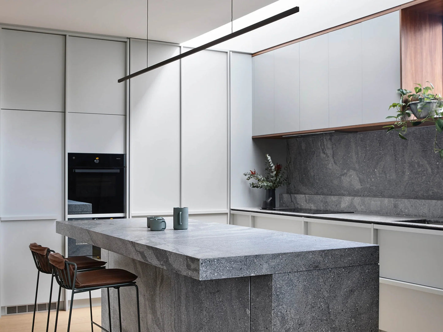 Highline Linear Pendant in Black with Grey Marble Kitchen Island and Backsplash