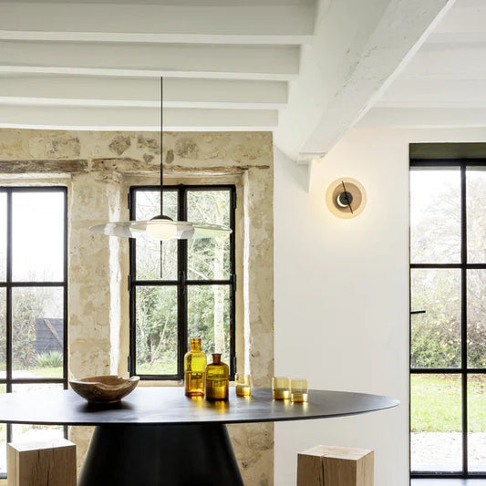 DCW Editions Mono pendant over large round table with wall light and beamed ceiling