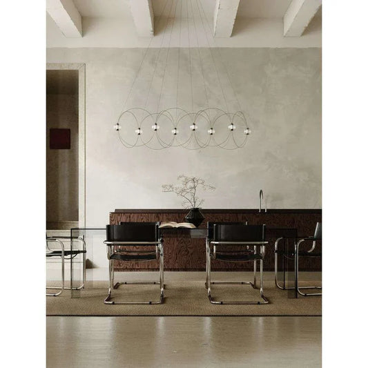 DCW Editions Munari pendant with 8 acrylic spheres and curved rods over glass conference desk with black chairs