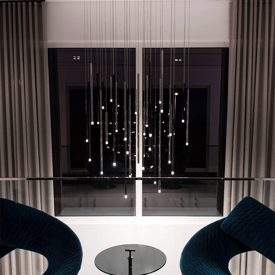 Lodes A-Tube Nano pendant cluster with black finish in entrance of modern house at night