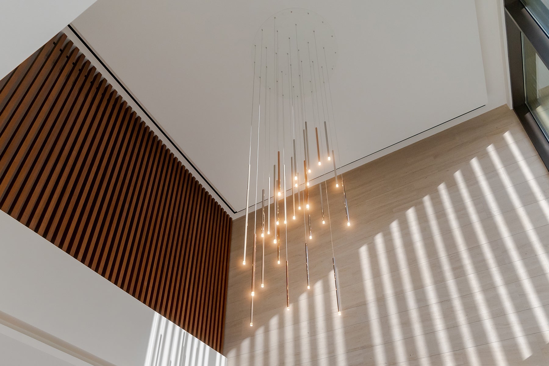 Lodes A-Tube Nano pendant cluster in entrance hall with wooden slats