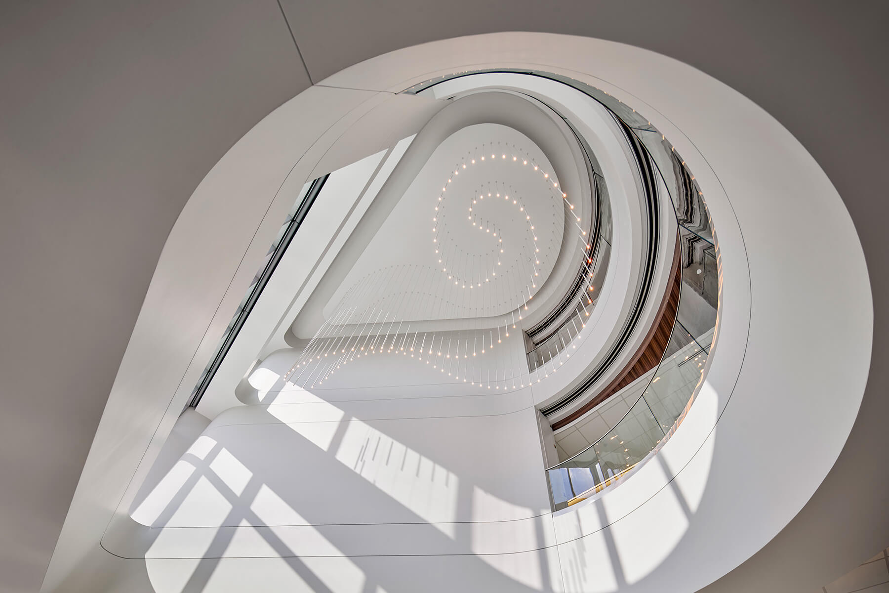 Lodes A-Tube Nano pendants in multi-story staircase in a swirl pattern