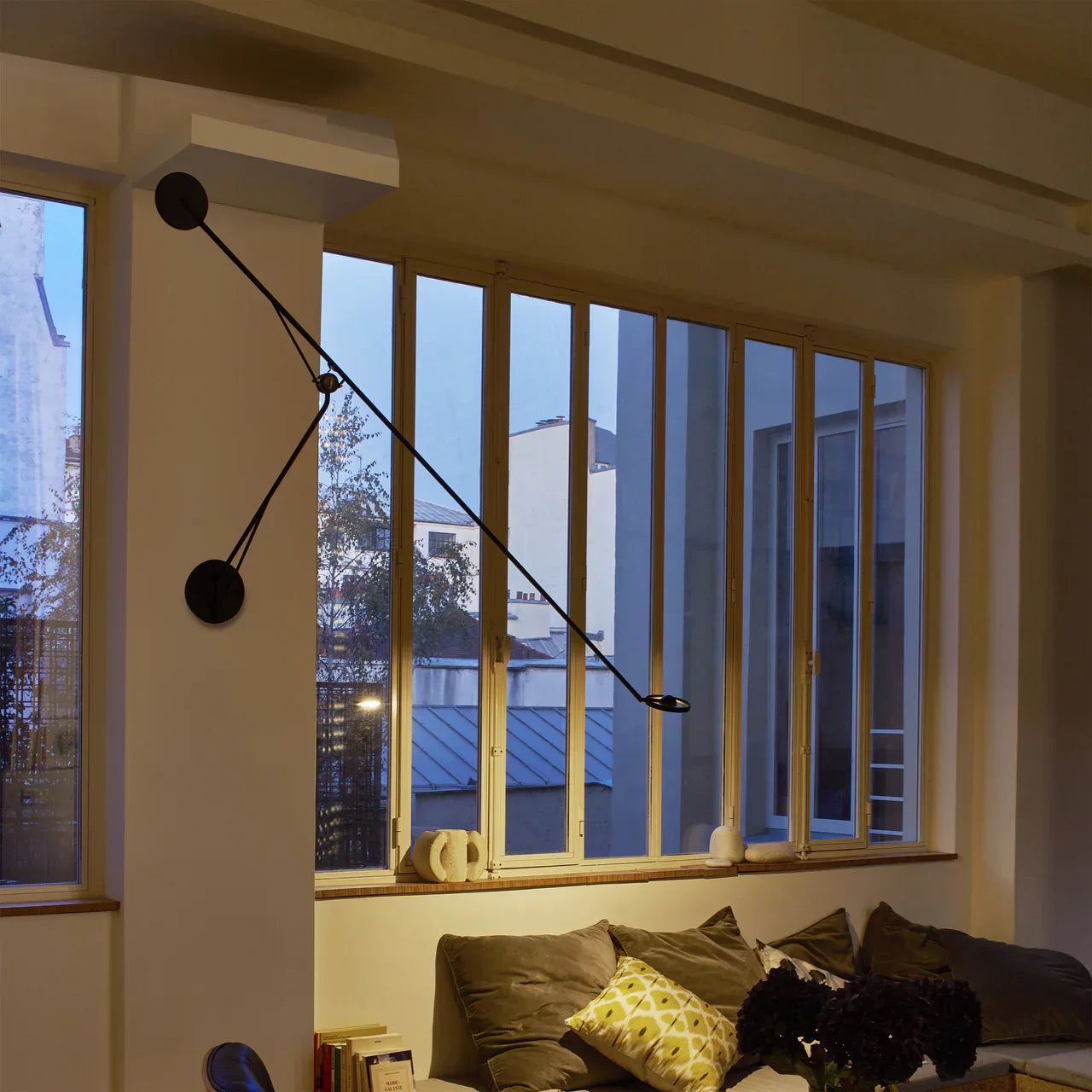 DWC Editions Aaro wall light over illuminated sofa with many cushions