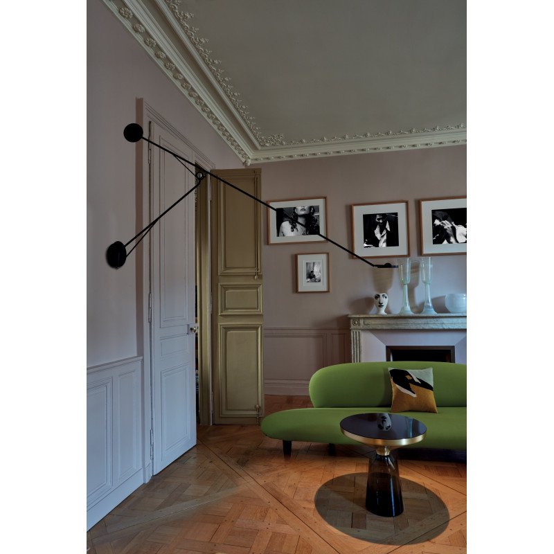 DWC Editions Aaro wall light over small, black, round coffee table with green sofa