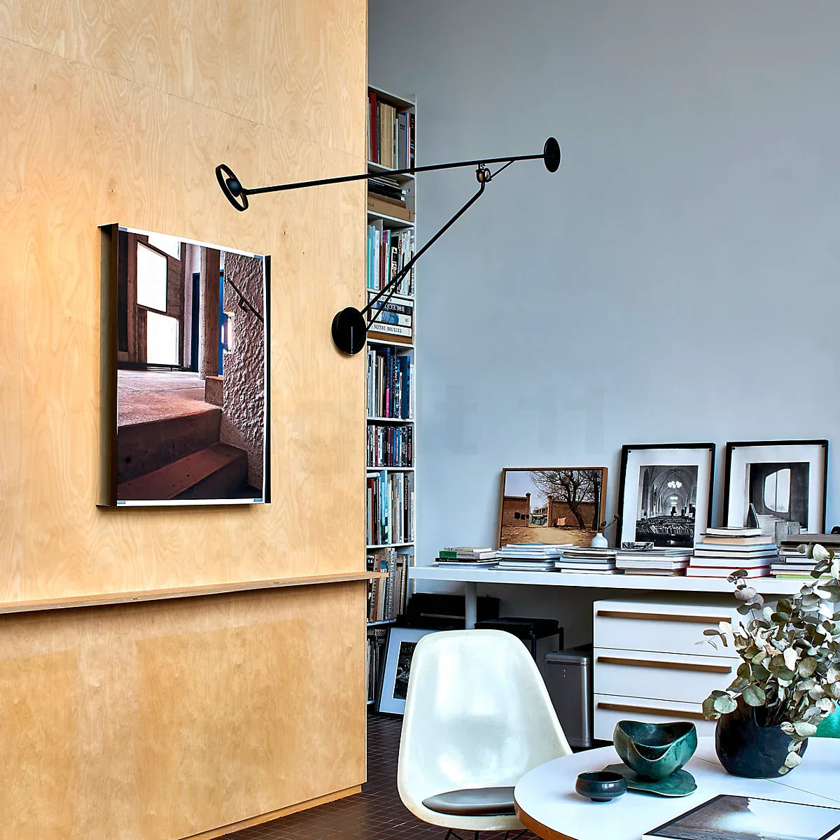 DWC Editions Aaro wall light over on ochre coloured wall pointing at art work