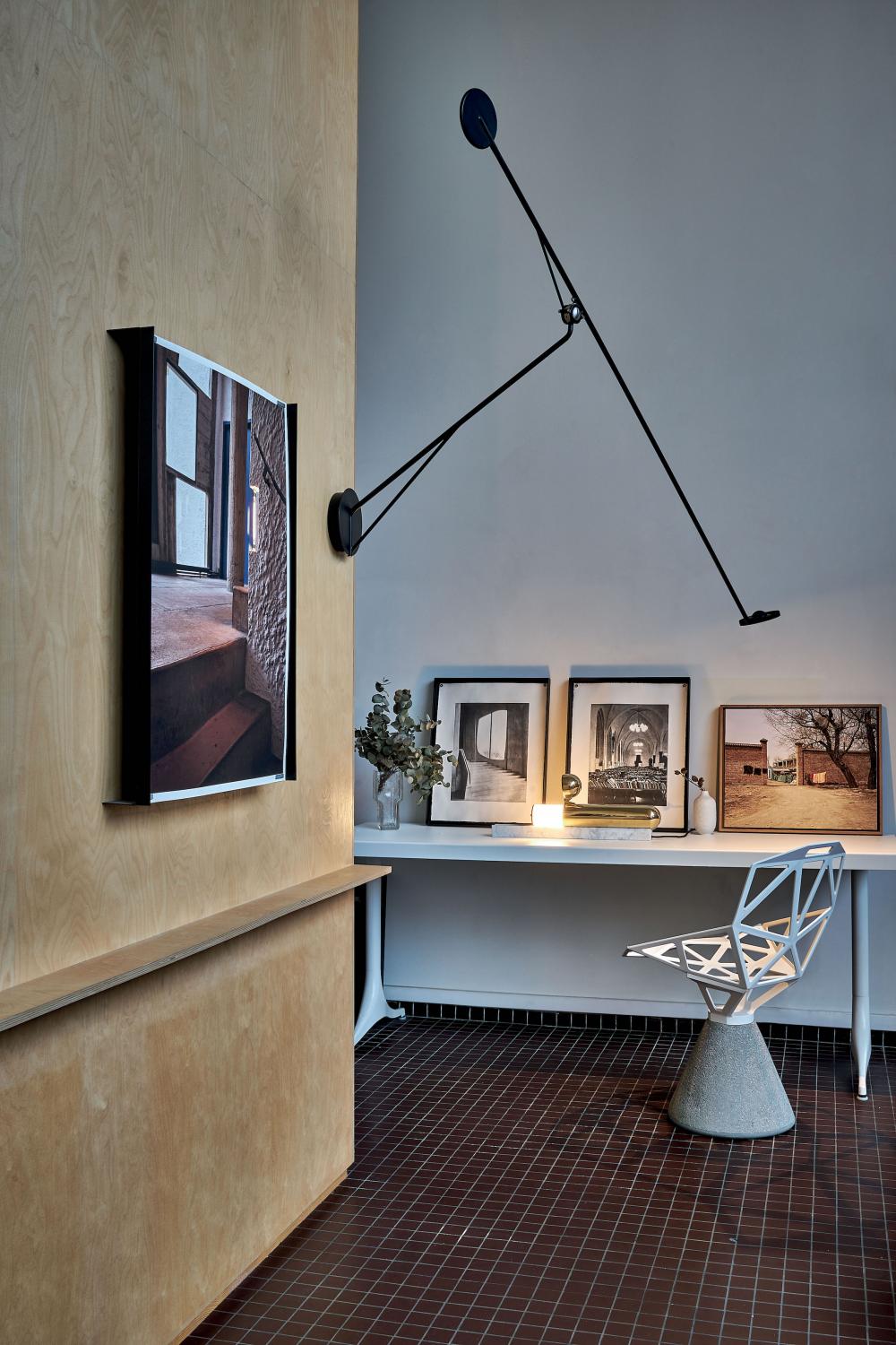 DWC Editions Aaro wall light over illuminated desk with art work