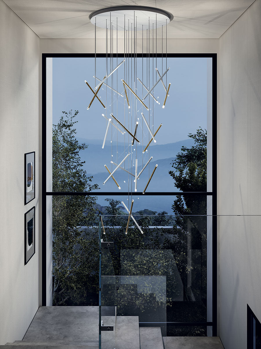 Lodes A-Tube Nano Duo champagne finish in a cascading cluster in a staircase in front of a large picture window