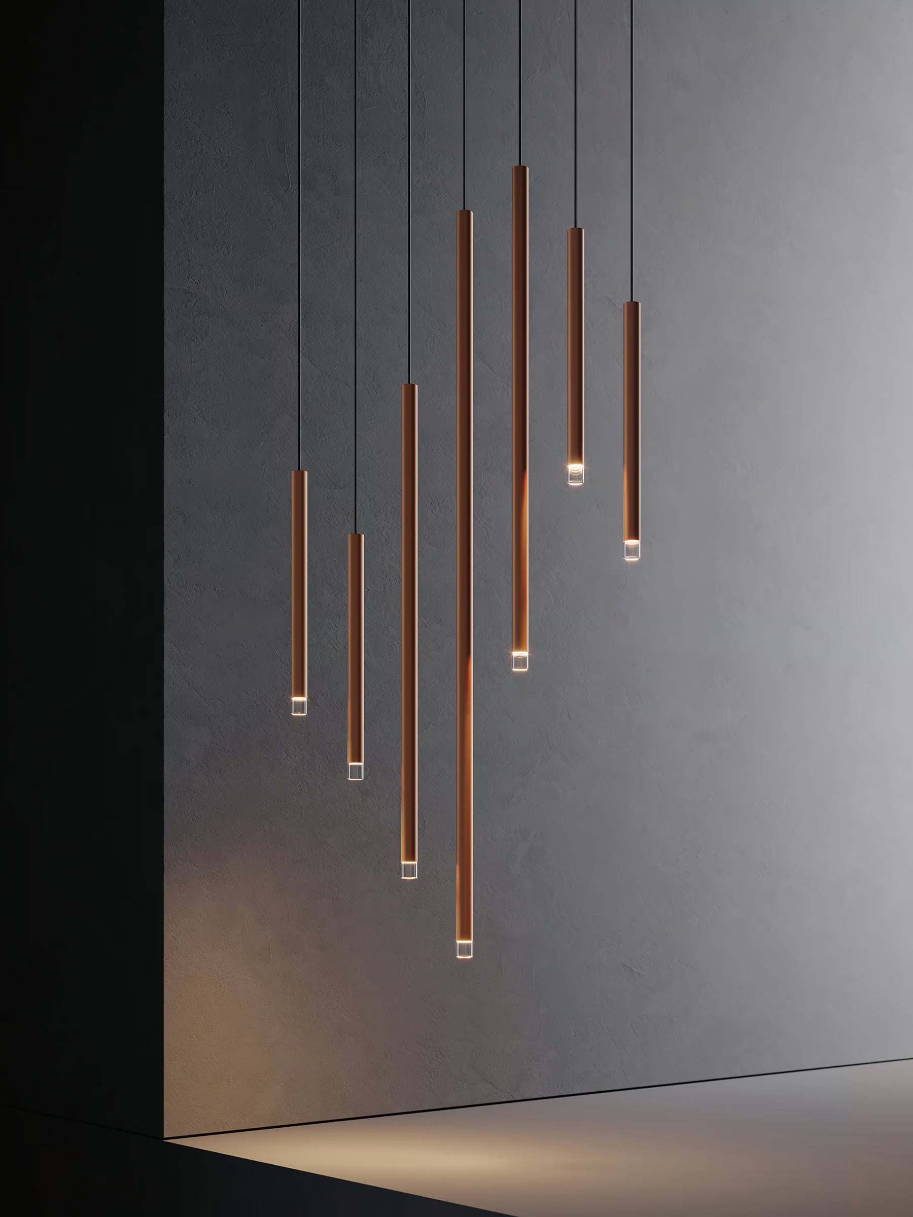 Lodes A-Tube Nano pendants in terra finish illuminated in different lengths in dark room
