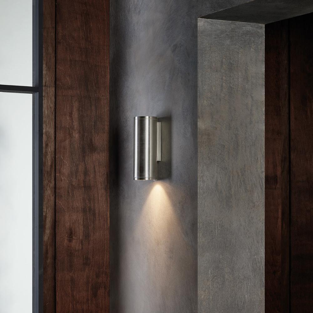 Modern wall-mounted light fixture on a concrete wall with wooden panels.