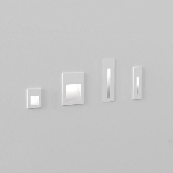 Set of four rectangular mirrors of different sizes on a gray wall.
