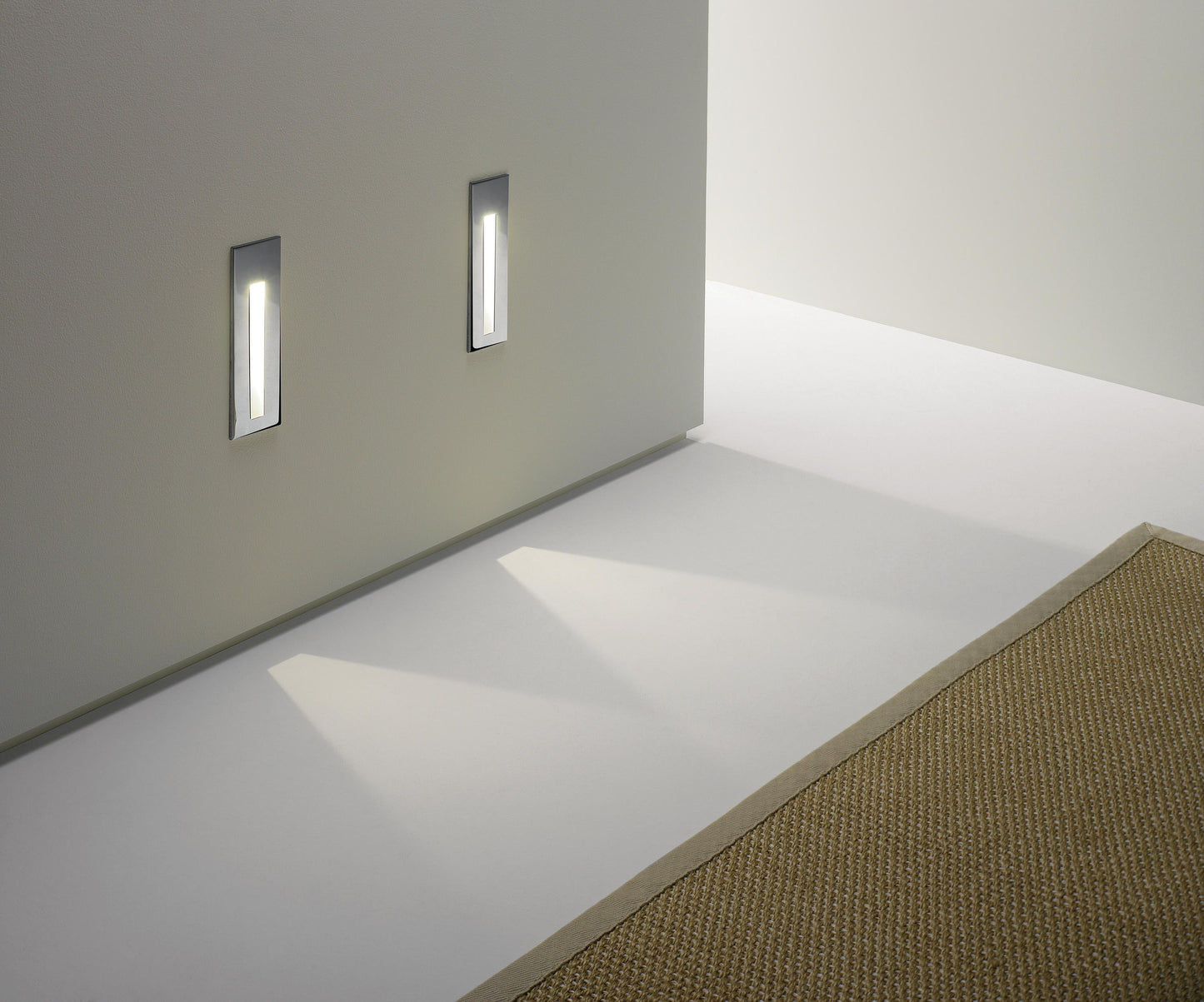 Two wall-mounted lights on a white wall with a light on the floor.