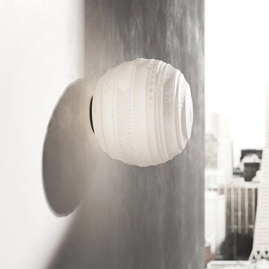 Wall-mounted light fixture with a textured white glass shade on a grey wall.
