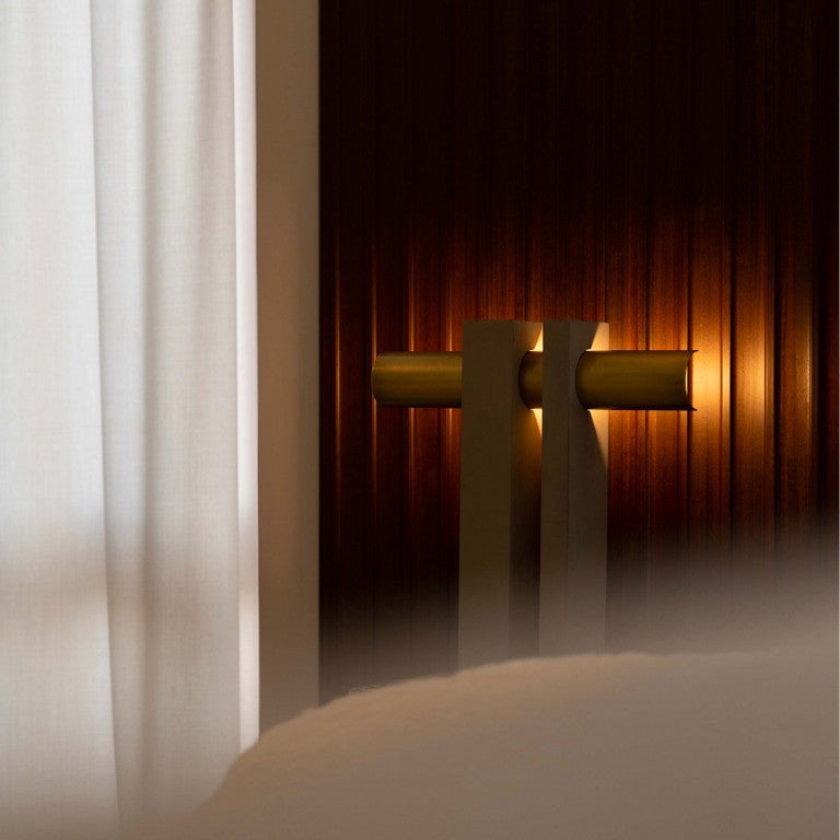 DCW Editions Pi table lamp in brass and bronze with backlighting onto wooden wall