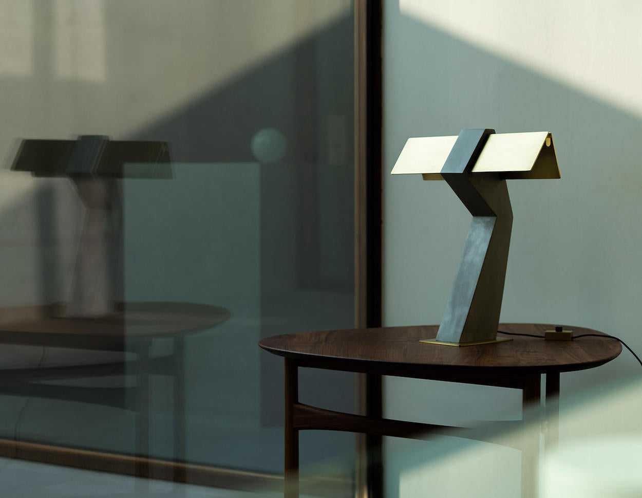 DCW Editions Iota table lamp in brass and bronze on wooden side table