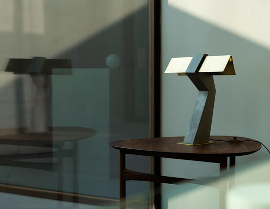 DCW Editions Iota table lamp in brass and bronze on wooden side table