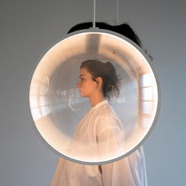 DCW Editions white Focus pendant with woman standing behind shade