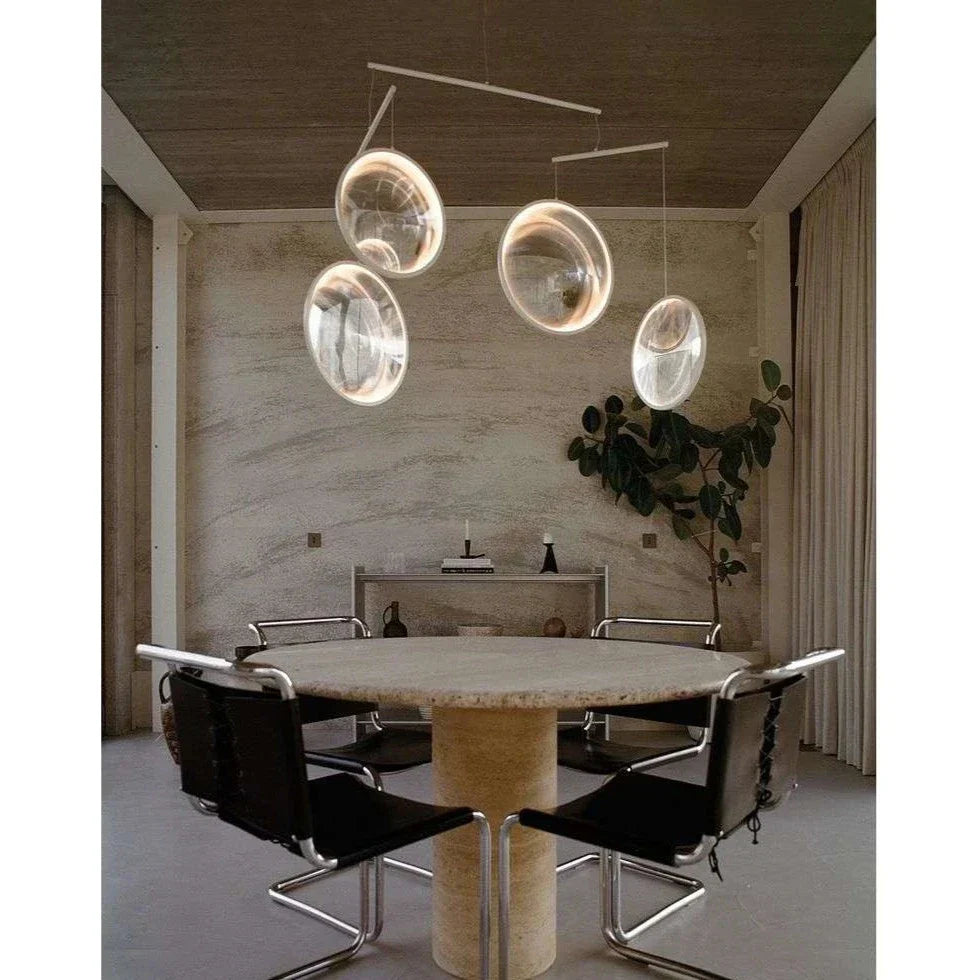 DCW Editions white Focus pendant with 4 circles over round dining table with black chairs