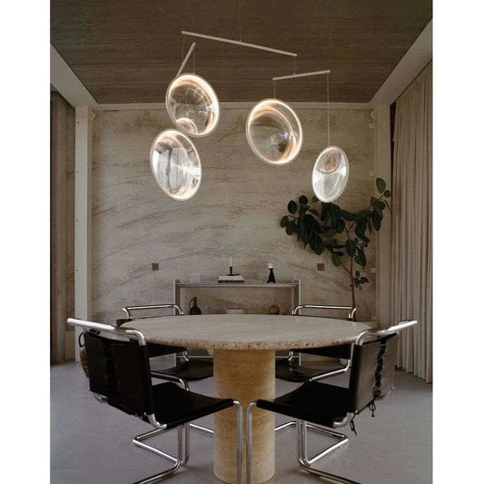 DCW Editions white Focus pendant with 4 circles over round dining table with black chairs