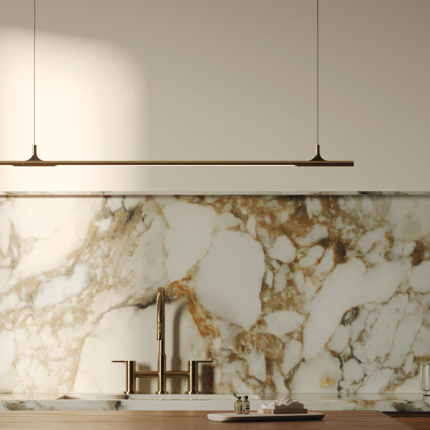 Modern kitchen with marble backsplash, gold fixtures, and pendant lights.