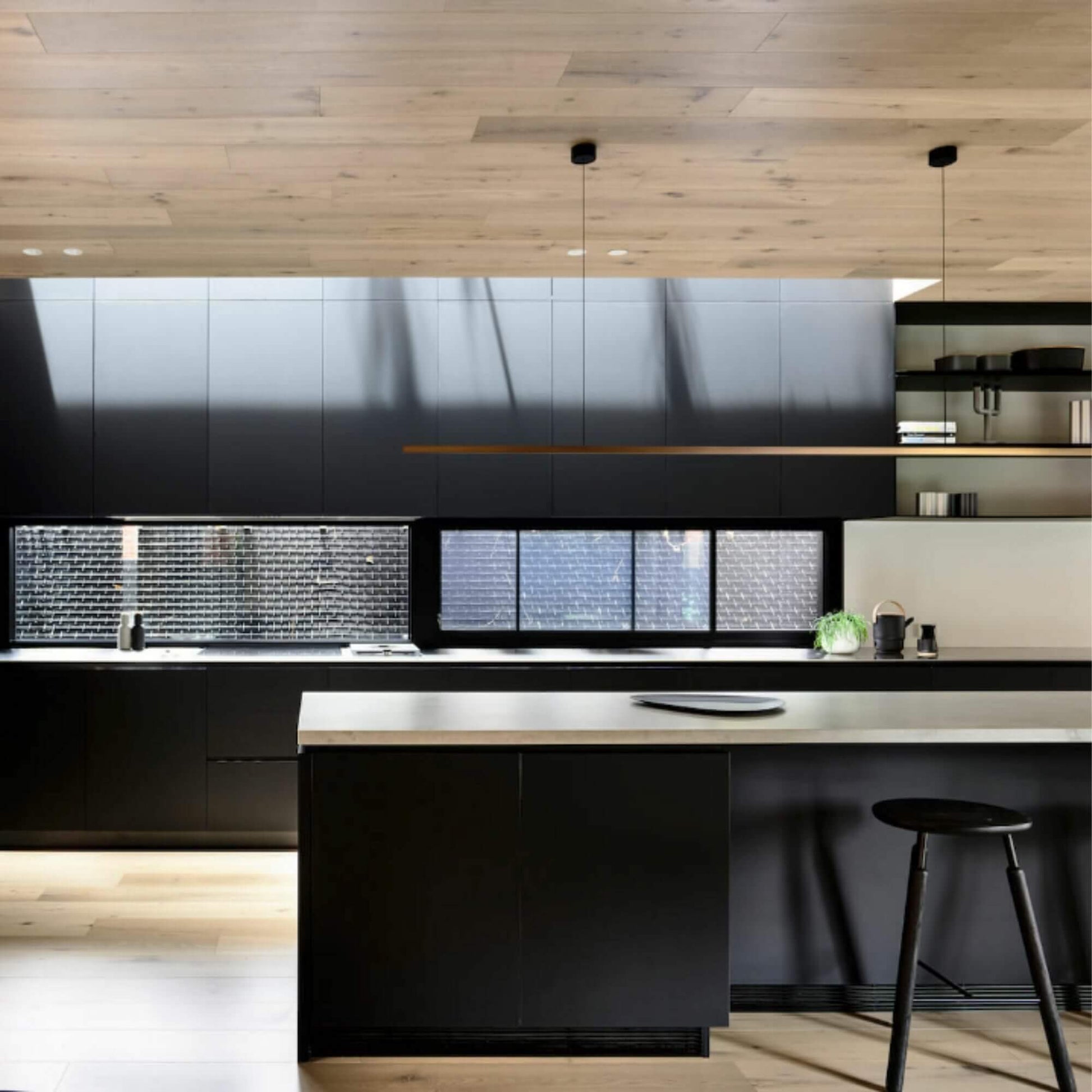 Highline Linear Pendant Patina Brass over Sleek Kitchen Island with Wooden Ceiling