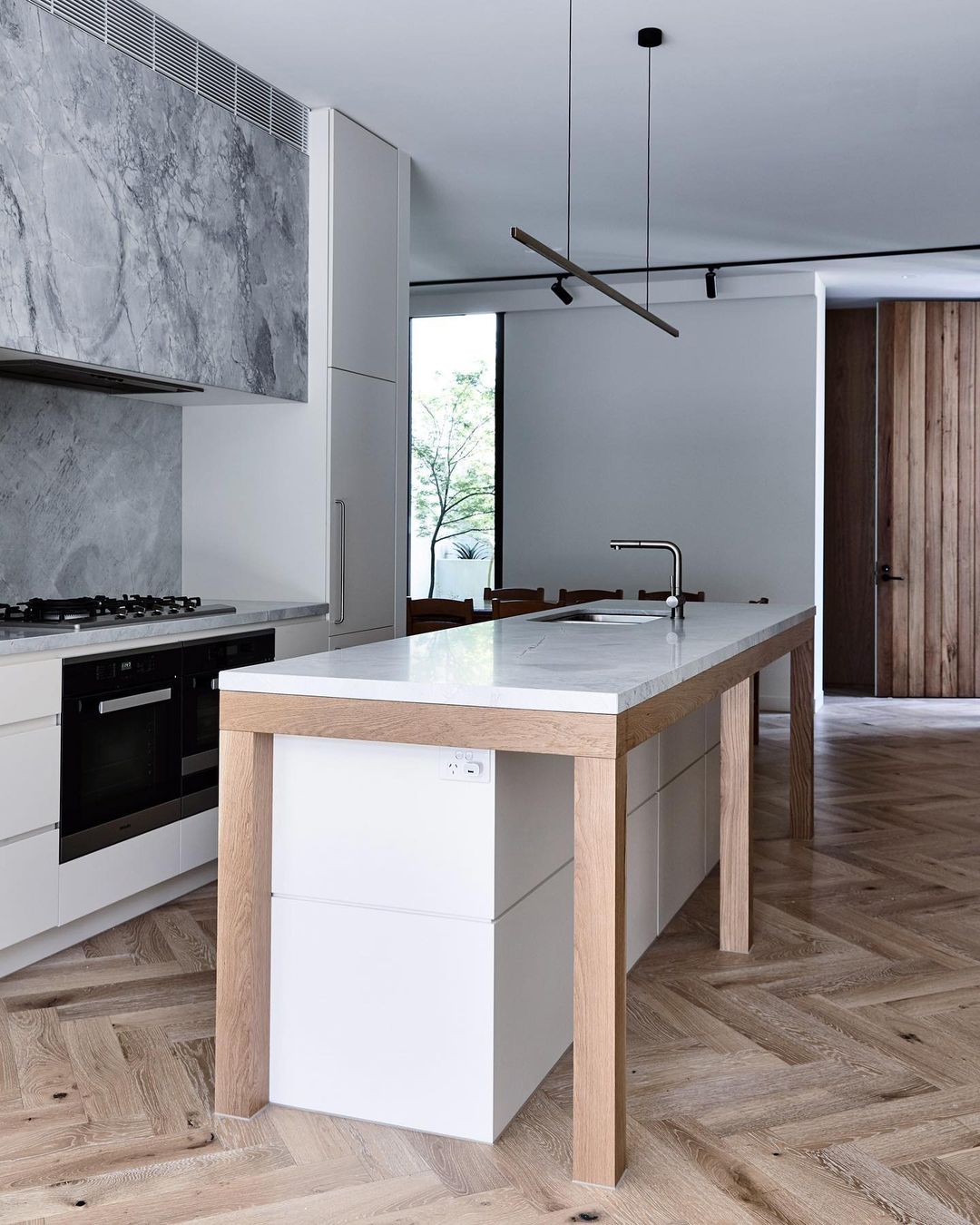 Highline Linear Pendant in Black over Modern Kitchen Island with Herringbone Flooring