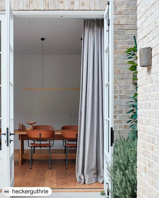 Highline Linear Pendant in Brass over Casual Dining Table with High Ceilings