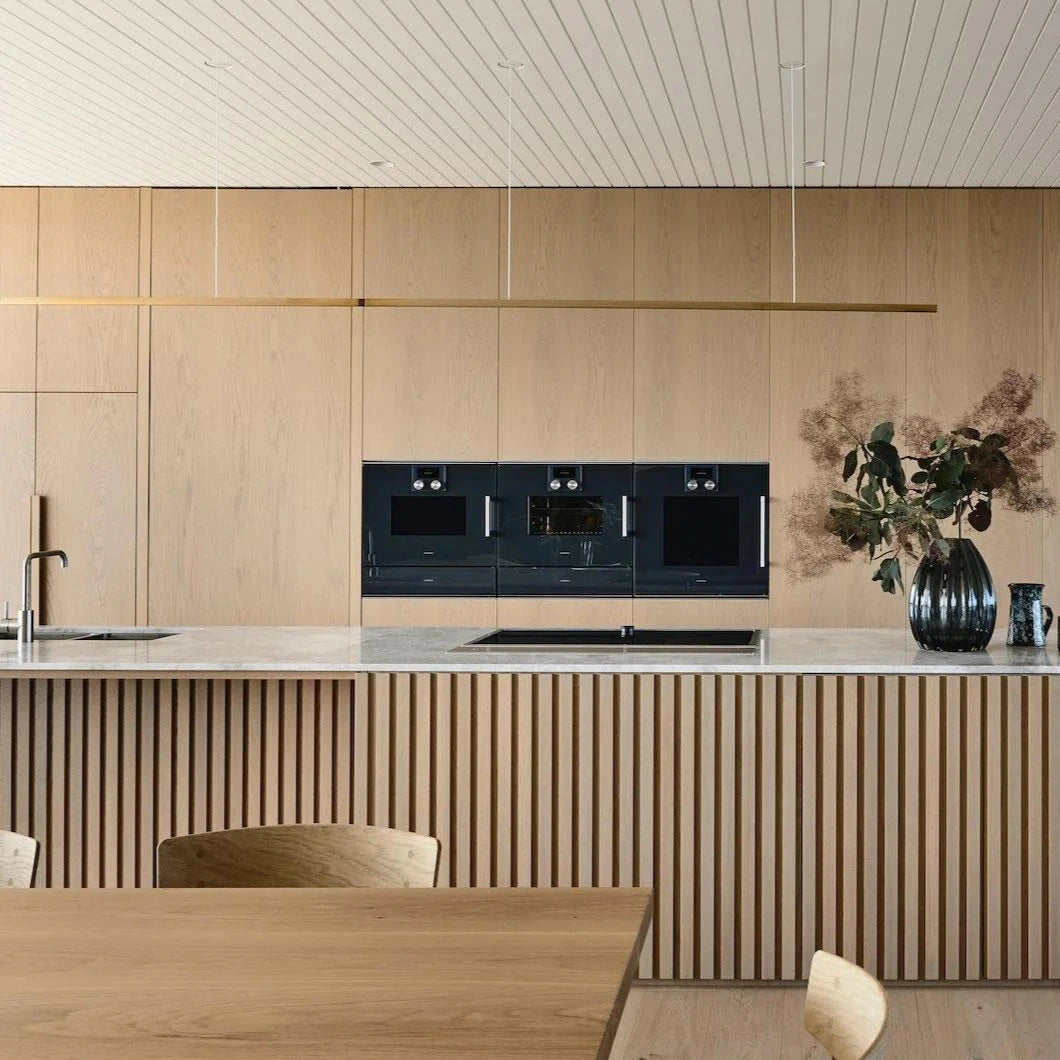 Highline Linear Pendant in Brass over Slatted Kitchen Island with Marble Top