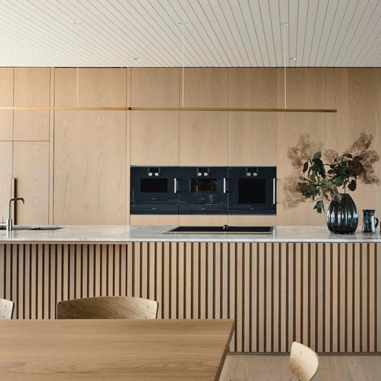 Highline Linear Pendant in Brass over Slatted Kitchen Island with Marble Top