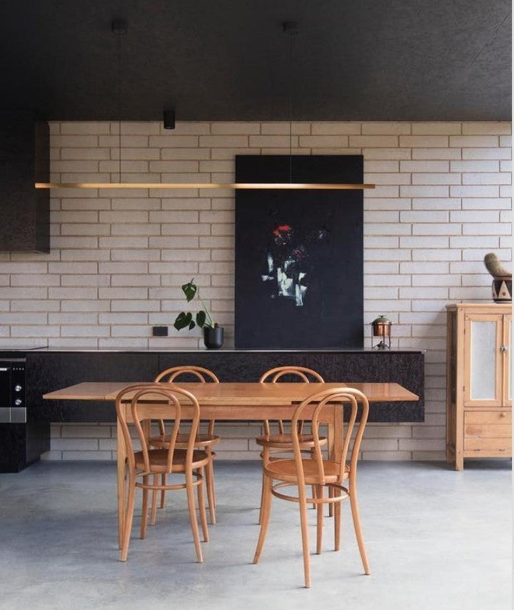 Highline Linear Pendant in Brass over Small Wooden Dining Table