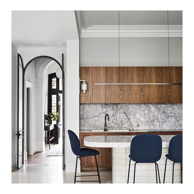 Highline Linear Pendant in Patina Brass over White Marble Kitchen Island with Wood Cupboards