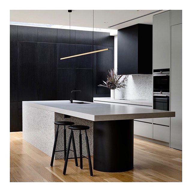 Highline Linear Pendant in Satin Brass over Modern Kitchen Island with Black Cabinets