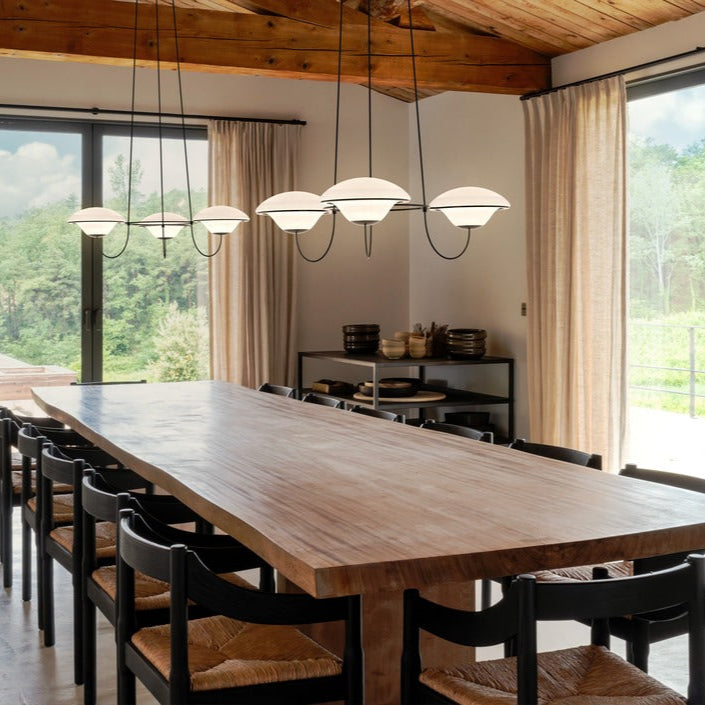 DCW Editions In The Air pendant with 3 shades over large wooden dining table
