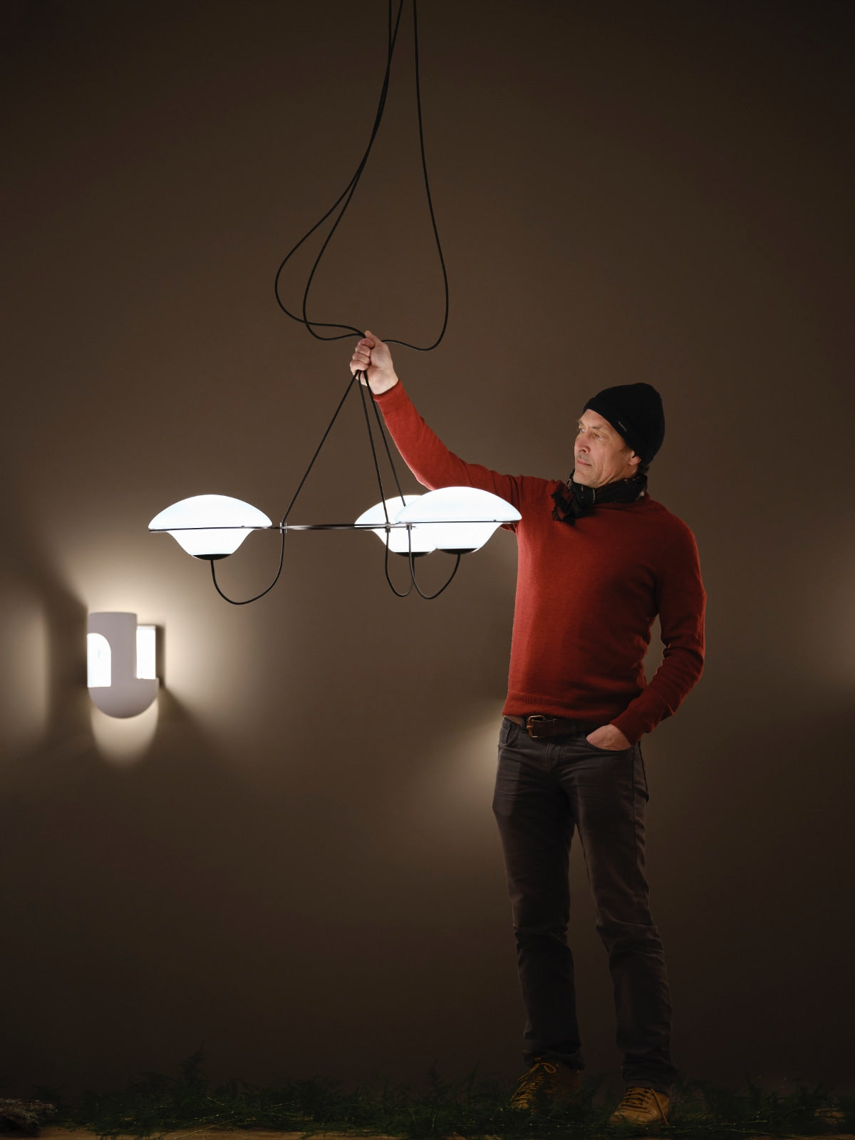DCW Editions In The Air pendant with 3 shades being held by the designer