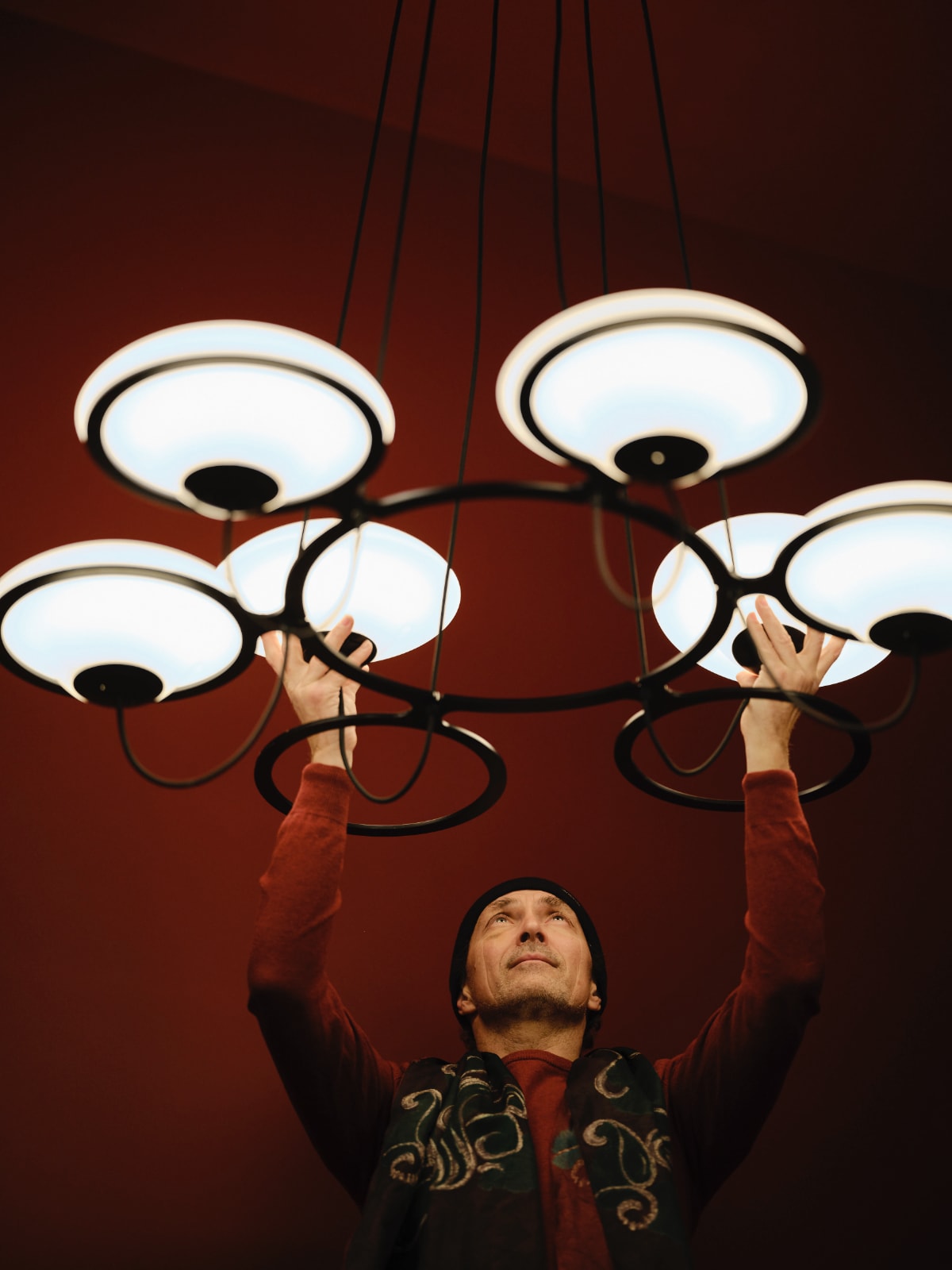 DCW Editions In The Air pendant with 5 shades being lifted by the designer