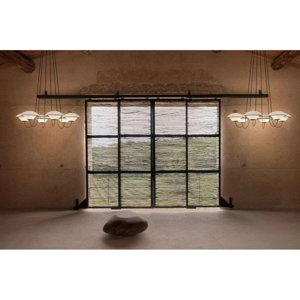 DCW Editions In The Air pendant with 5 shades in empty room with rustic walls and large window