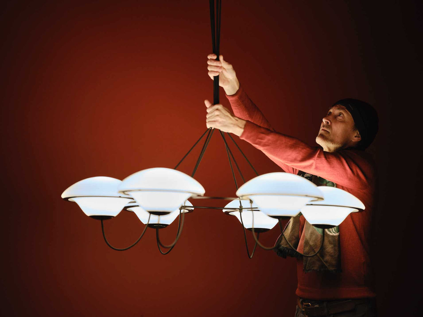 DCW Editions In The Air pendant with 5 shades being held by the designer