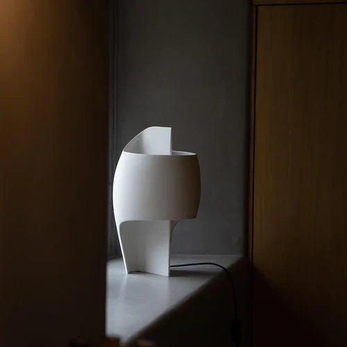 DCW Editions Lamp B table lamp on a window sill with wooden furniture nearby