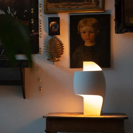 DCW Editions Lamp B table lamp on small side table with art work on the walls