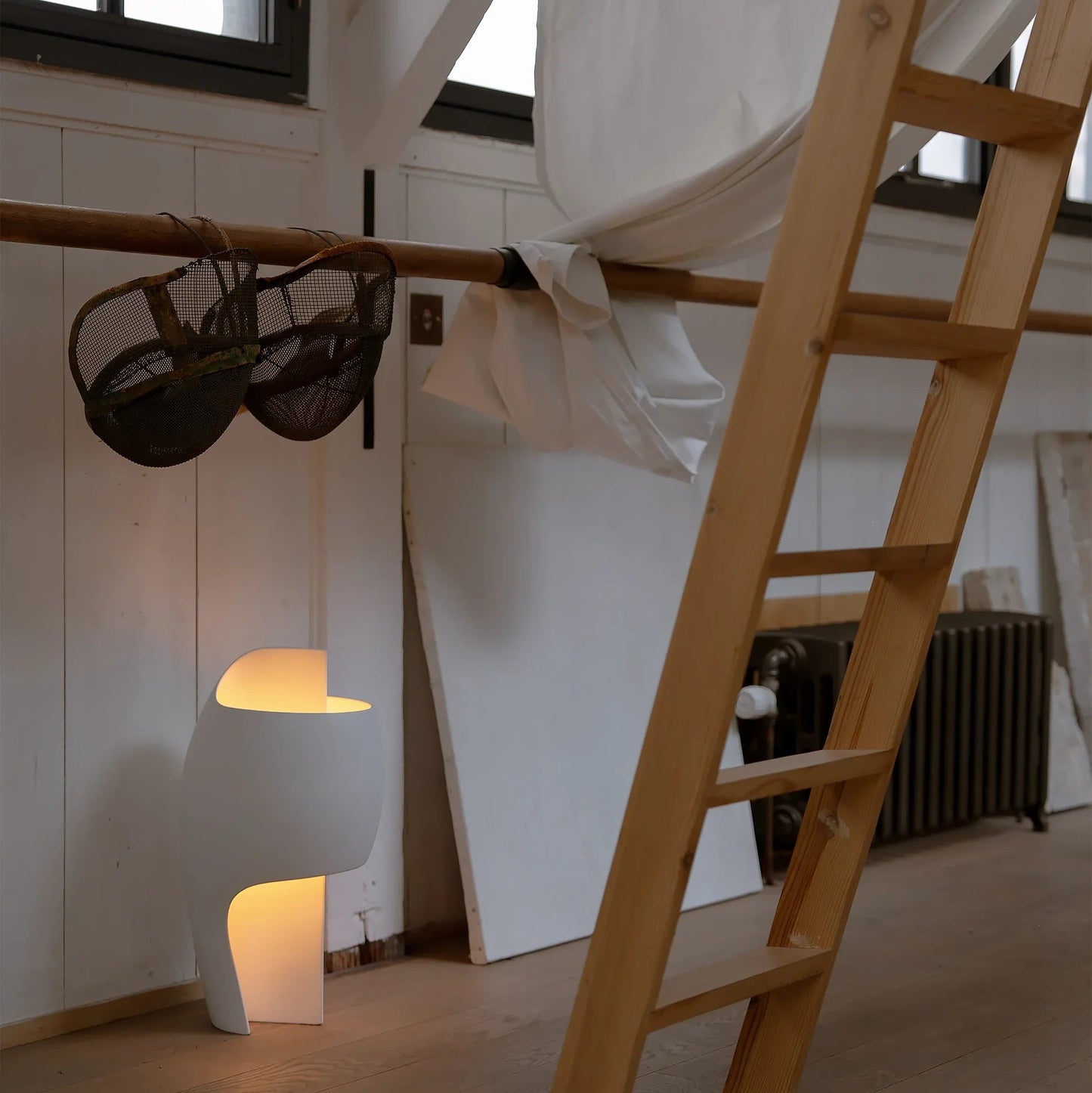 DCW Editions LampeB Grande table lamp on floor of dance studio with ladder in the foreground