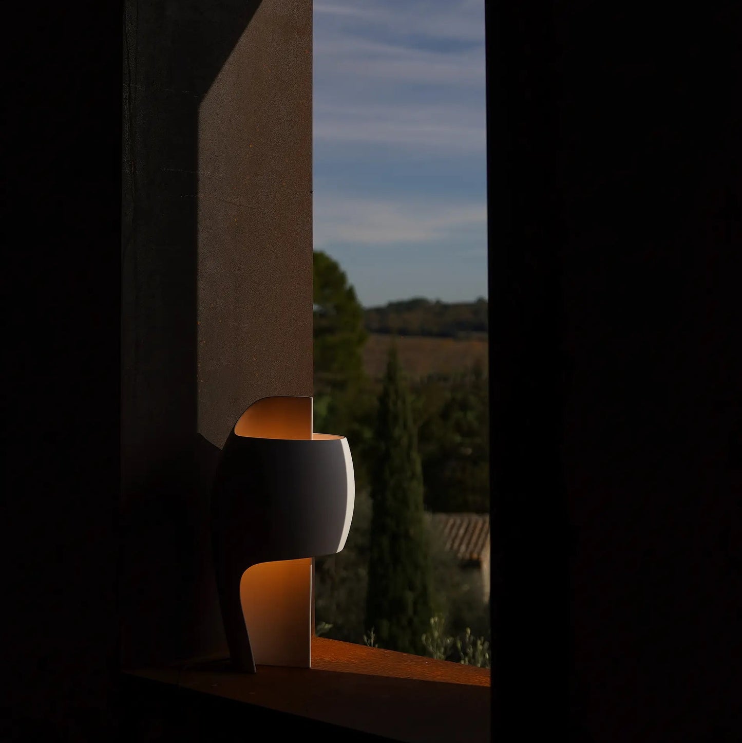 DCW Editions LampeB Grande table lamp softly lit at dusk, in an open window
