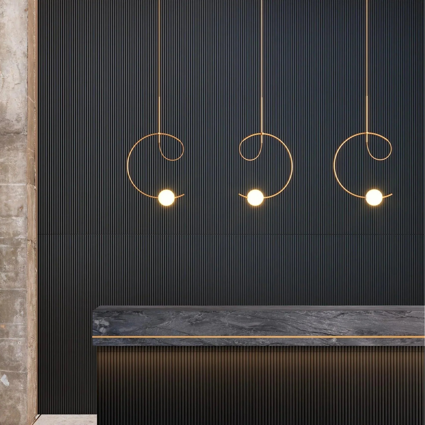 Estiluz Loop Pendants in gold finish with white glowing spheres hanging over stone reception desk with dark walls