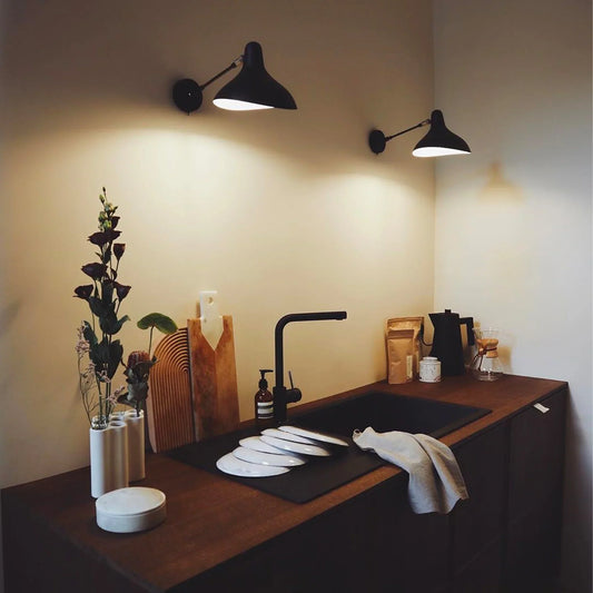 DCW Editions Mantis wall light standard BS5 with thumbswitch over small, modern kitchen  with a black sink and white plates
