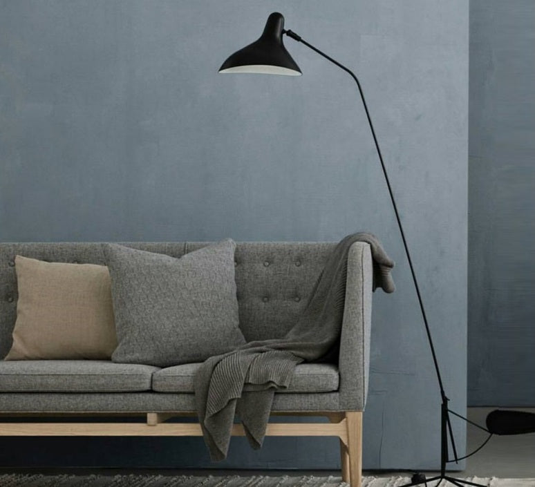 DCW Editions Mantis floor lamp BS1 next to grey sofa with cushions and a blanket