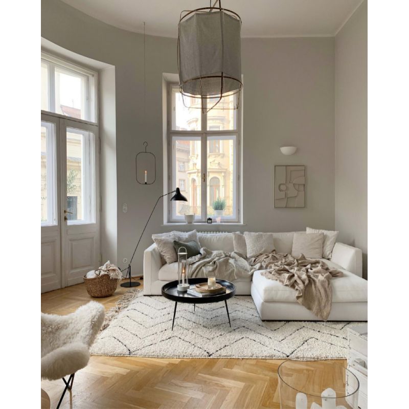 DCW Editions Mantis floor lamp BS1 in lounge with large pendant, a wall light and a hanging candle
