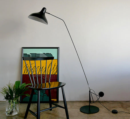DCW Editions Mantis floor lamp BS1 with black chair, flowers, and art print