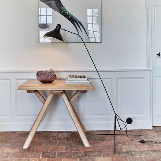 DCW Editions Mantis floor lamp BS1 over small square table with large crystal on brick floor