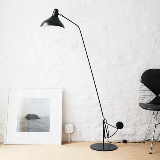 DCW Editions Mantis floor lamp BS1 with a white plaster wall with a framed photograph